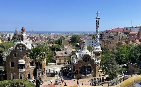 The gatehouses of Park Güell with Barcelona and the sea beyond, and the Sagrada Família on the skyline
