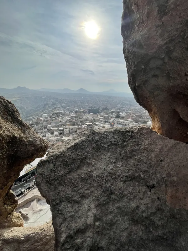 Low winter sun shining between two rocks above the village of Uçhisar