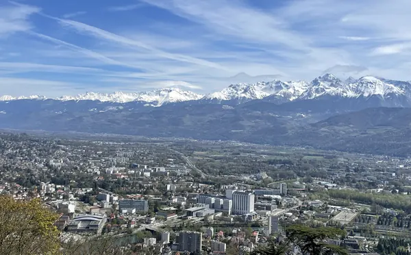 Grenoble spread across the valley floor with the snow-covered Belledonne mountains behind