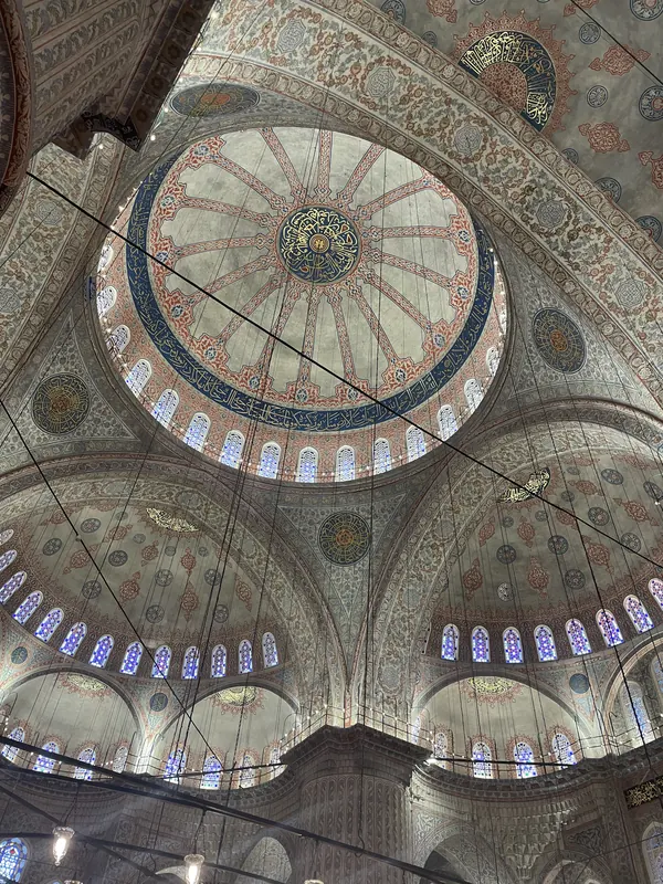 Looking up into the domes of the Blue Mosque, covered in blue and red painted patterns and ringed with windows