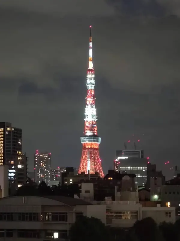 Tokyo Tower lit in red and white above the city at night