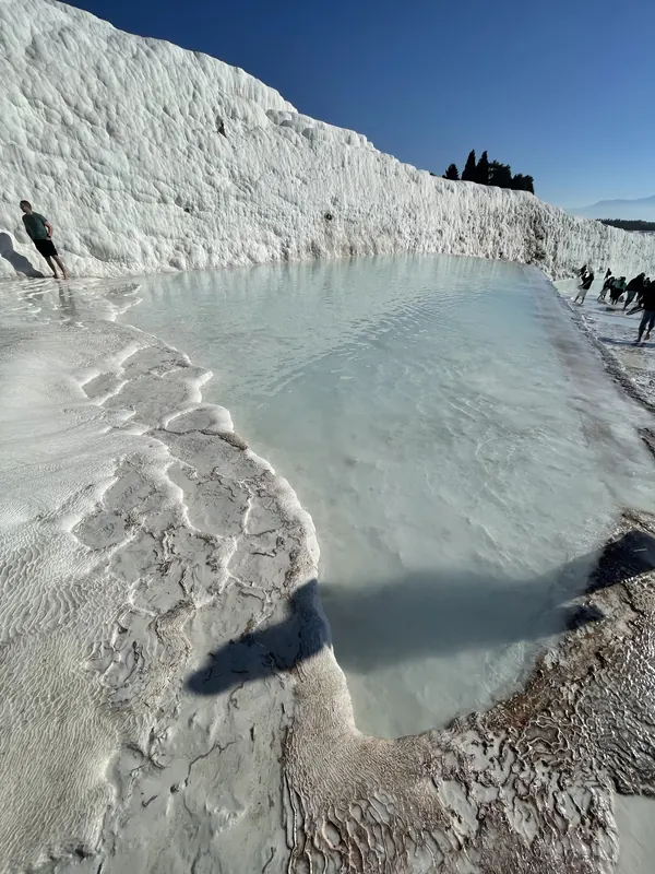 A milky turquoise pool cupped in the white travertine terraces of Pamukkale