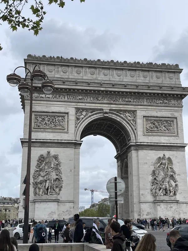The Arc de Triomphe framed by a street lamp and spring leaves