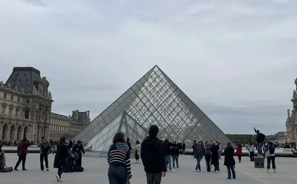 The glass pyramid in the courtyard of the Louvre, with the palace wings on either side